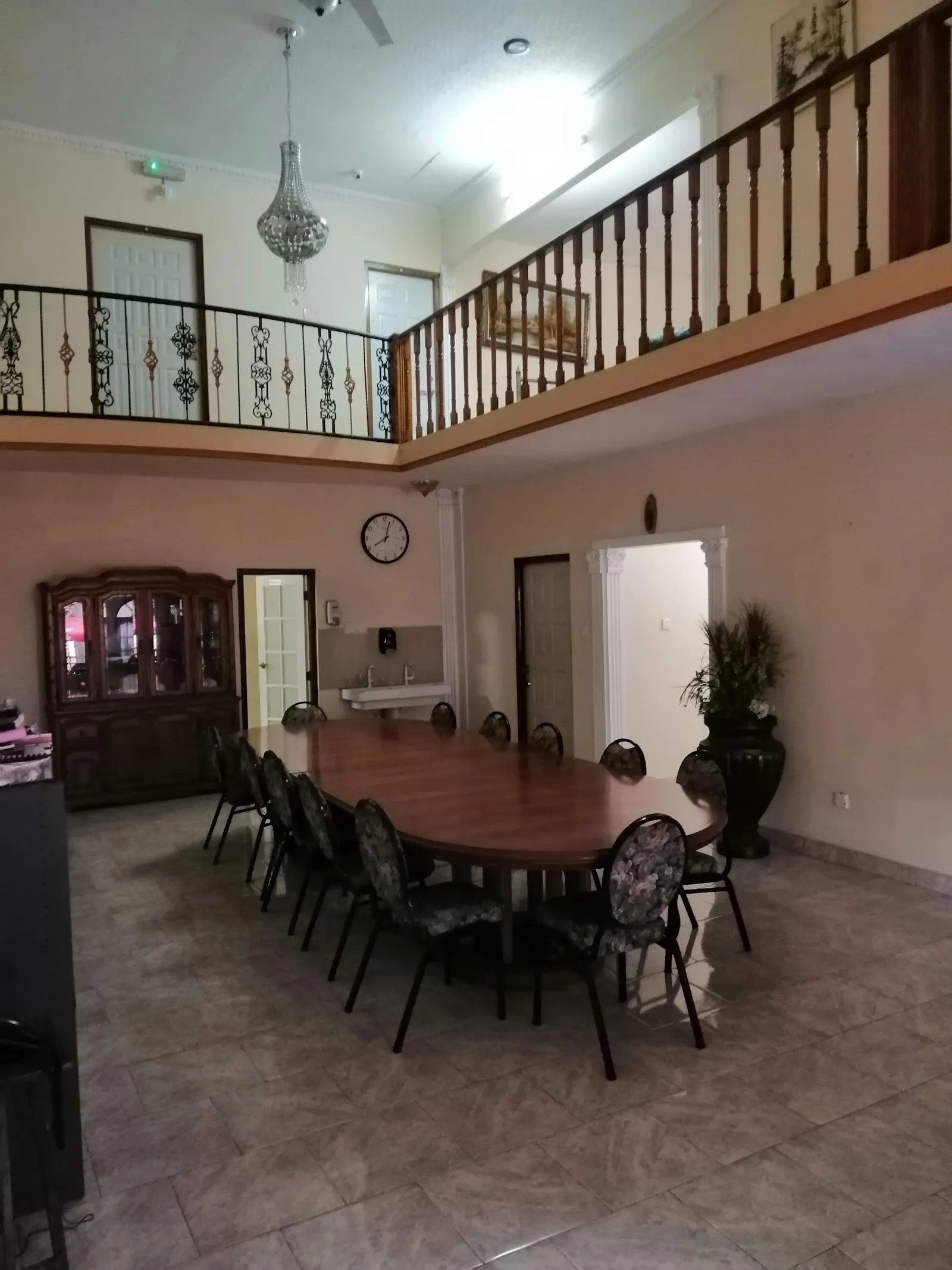 Banquet hall dining area with long table and balcony above