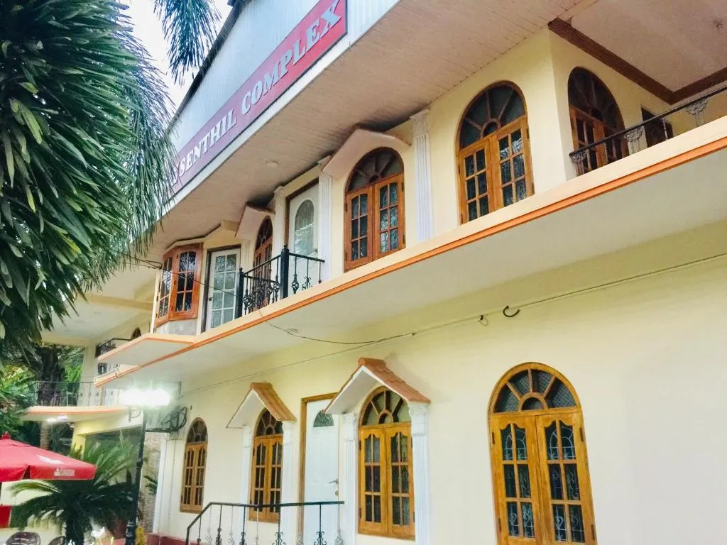 Senthil Complex building with arched wooden windows and name board