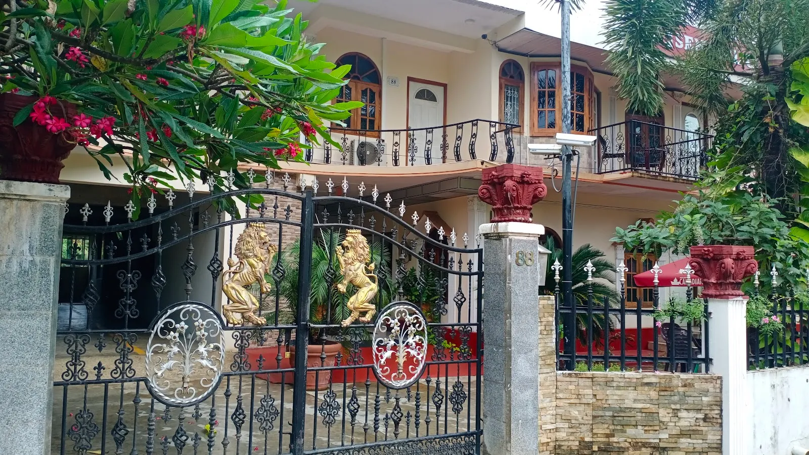 Decorative iron entrance gate with lion statues at Senthil Complex