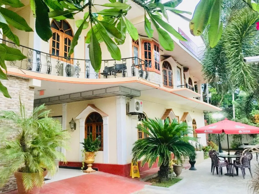 Garden patio with tables, umbrellas and tropical plants