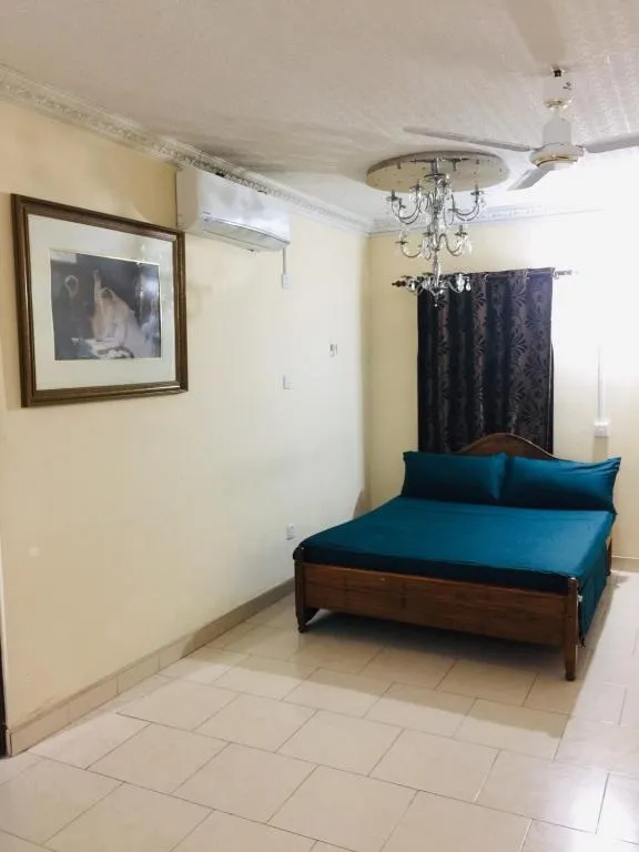 Queen room with teal bedding, chandelier and air conditioning